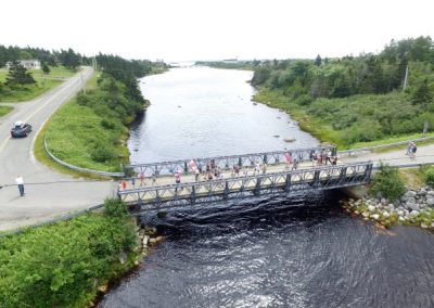 Tor Bay Acadien Society - 2016 Festival Savalette: Tintamarre Marchers crossing “le gros pungue (pont)” at “le pchit (petit) basin”